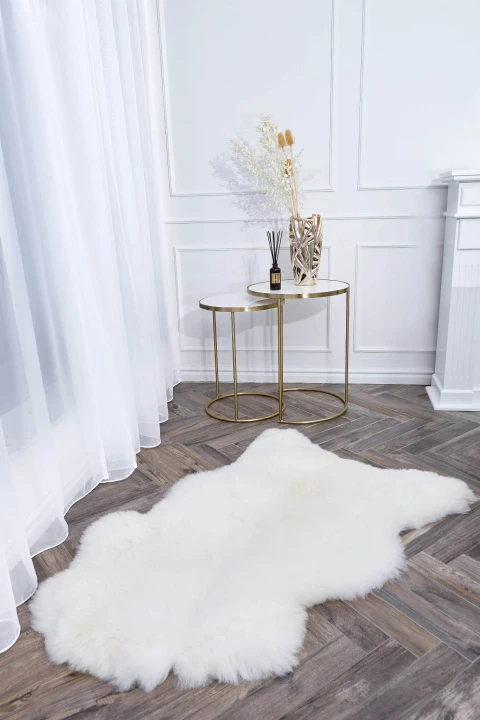 Soft and fluffy natural sheepskin rug in white colour.